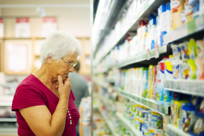 Senior woman choosing a dairy products at supermarket