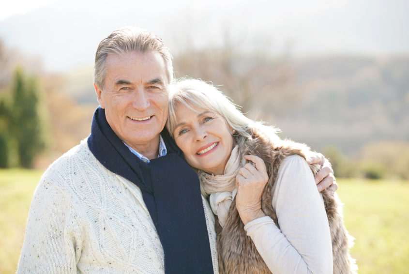 Portrait of cheerful senior couple enjoying day in countryside