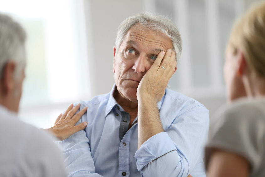 Senior man attending meeting with group therapist