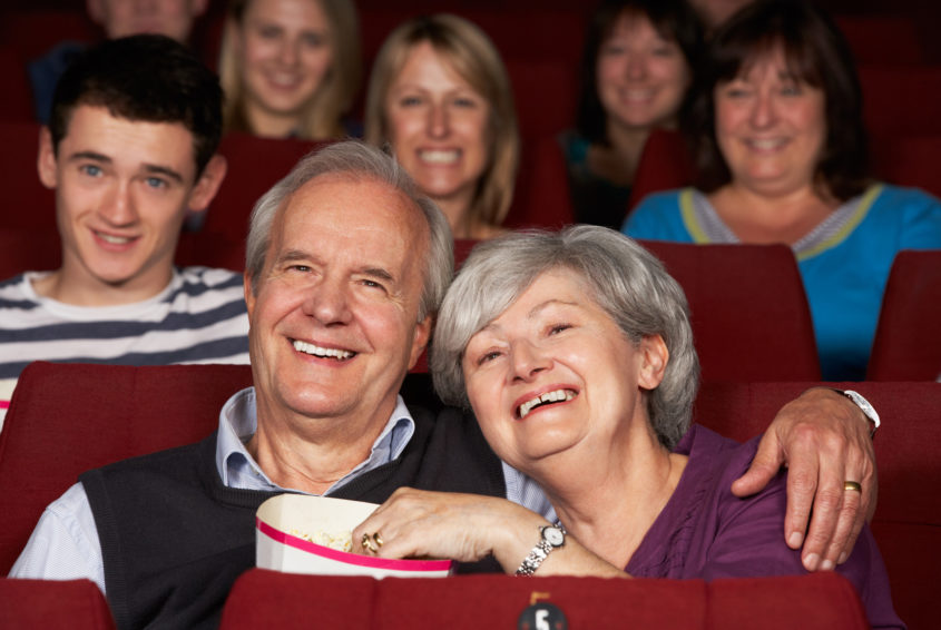 Senior Couple Watching Film In Cinema