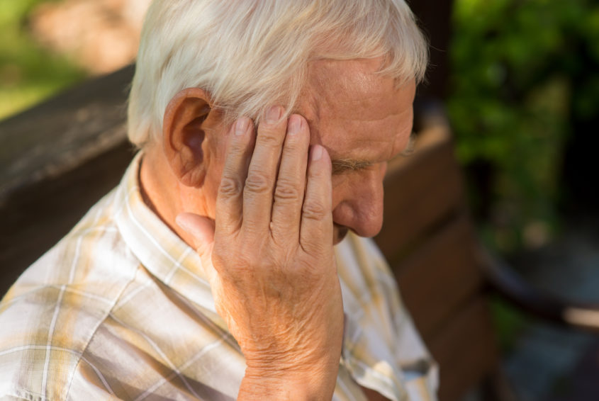 Senior man holds his head.