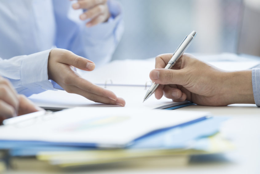 A man is signing a contract