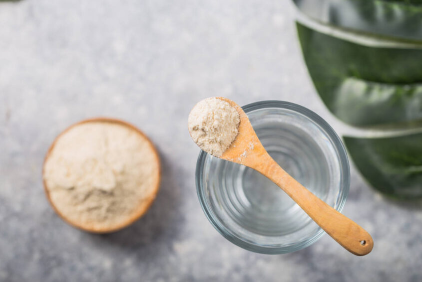 Glass of water, collagen powder on white table. Healthy lifesty kolagen do picia