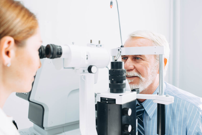 Senior man getting eye exam at clinic, close-up